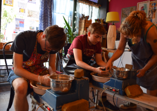 Young people using pottery wheel